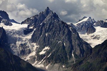Fototapeta na wymiar Mountains with glacier in clouds before rain