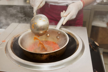 Chef is stirring sauce in wok