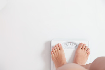 体重を測る女性・白バック