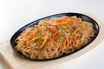 crystal noodles with vegetables in a pan isolated cast iron wok