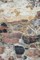 The texture of old stone wall of different color stones.