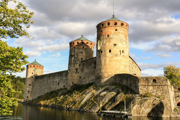 Fototapeta na wymiar Ancient fortress Olavinlinna in Savonlinna in Finland among the trees a summer day.