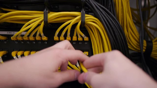 hands plug in the ethernet cable