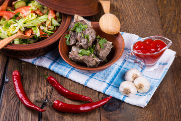 Roasted meat and vegetables on a wooden background