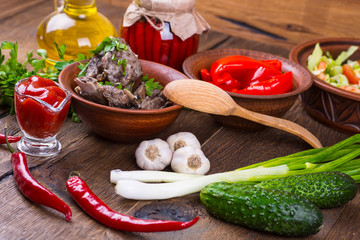 Roasted meat and vegetables on a wooden background