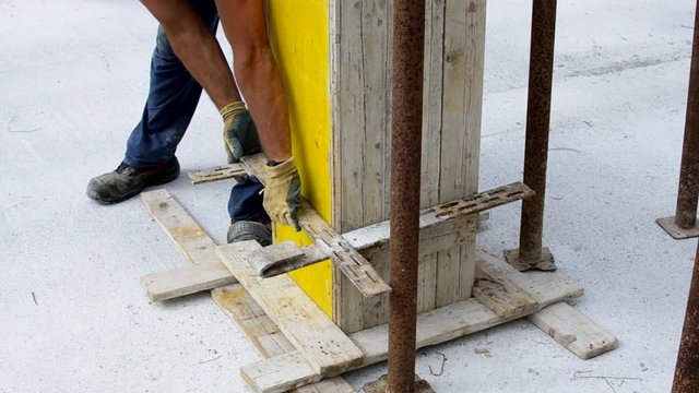 worker reinforces the wooden formwork with steel ties