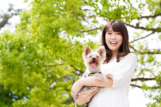 Portrait Of Young Asian Woman With Dog In The Park