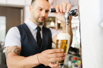 Barman serving beer in a pub.
