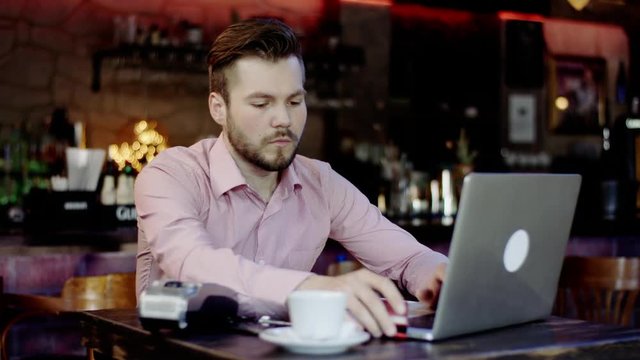 young business man paying with a credit card in a bar