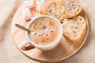 sweet buns, meringues and coffee cup on a wooden board