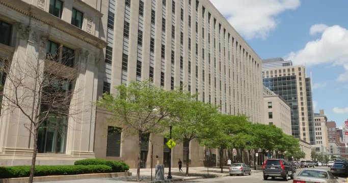 Cars pass by the John Hancock Building on Stuart Street.  	