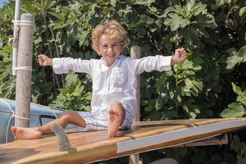 young boy smiling sitting on surfboards