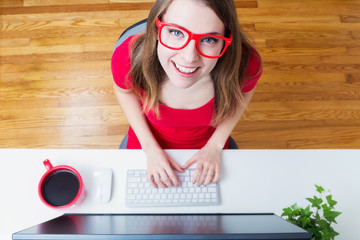 Happy young woman working in her home office from a high angle