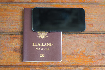 Passport and Mobile phone on wooden background