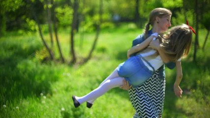 young mother with her daughter playing in a spring park