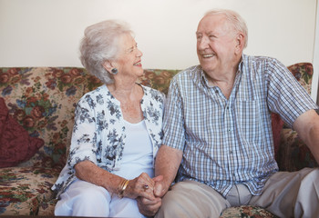 Loving senior couple sitting together at home