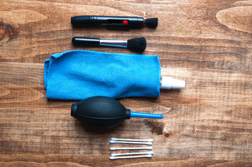 Equipment for cleaning camera on a wooden background from above