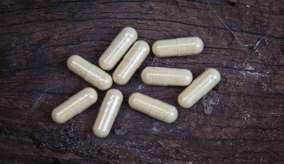 many capsule pill on wooden background