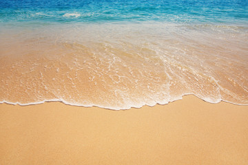 Fototapeta na wymiar beach background with soft waves on sandy ground, subtle vintage effect