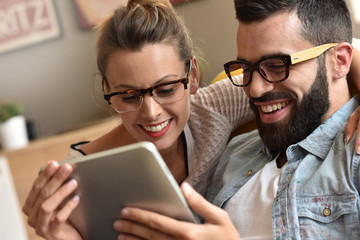 Hipster couple having fun using digital tablet