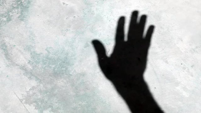 Video footage of a waving human hand shadow