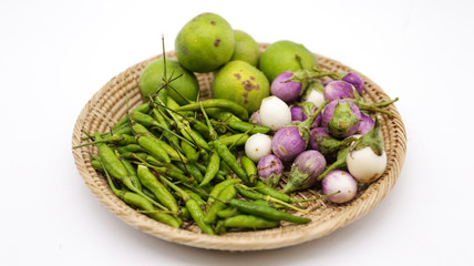 Chili , lemon and thai eggplant on wodden basket isolate on whit