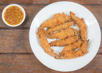 Fresh fried Shishamo fish on plate set on a wood table