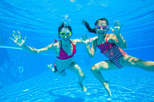 girl with mother playing  underwater