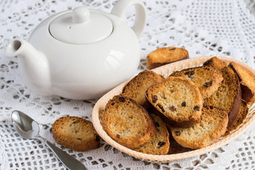  Homemade rusks.   Homemade rusks in a basket and a teapot on a white openwork tablecloth.