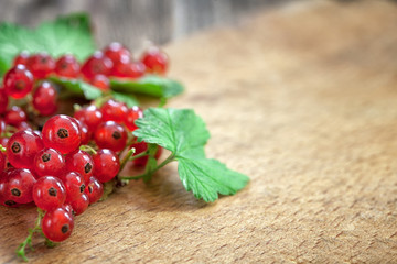 Organic red currant on wooden background with copy space 