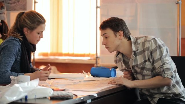 Woman shows man concept on schemes lying on table