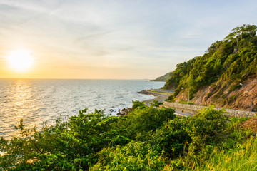 A scenery of road beside mountains and sea with the sunset time in Chanthaburi Thailand.