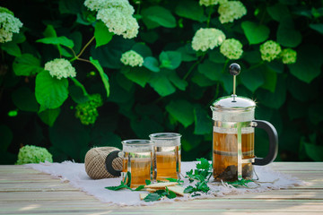 Cup of tea with mint, on table, on green background