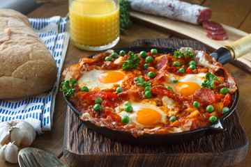 Eggs poached in tomato sauce and other vegetables served with bread.