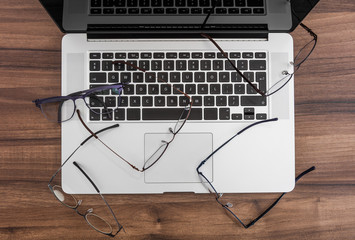 Laptop covered with glasses - obrazy, fototapety, plakaty