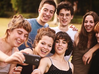 Obraz premium duża grupa przyjaciół razem w parku, bawiąc się i robiąc selfie
