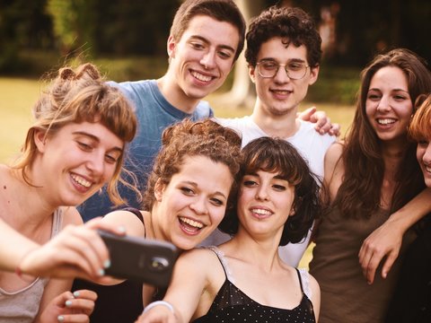 large group of friends together in a park having fun and taking a selfie
