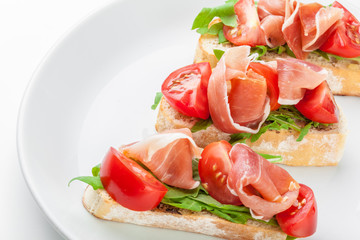 Jamon. Slices of Bread with Spanish Serrano Ham Served as Tapas. Cured ham, spanish appetizer. Prosciutto isolated on white background