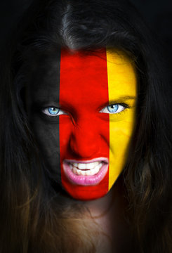 Portrait of a woman with the flag of the Germany painted on her face