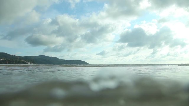 Beautiful clouds and waves of the sea. Tropical beach with yellow sand.