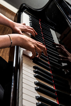 Mani di pianista sulla tastiera del pianoforte durante un&rsquo;esecuzione