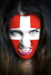 Portrait of a woman with the flag of the Switzerland  painted on her face
