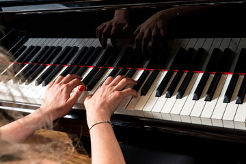 Mani di pianista sulla tastiera del pianoforte durante un’esecuzione