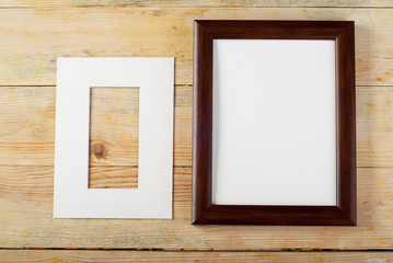 Blank frame on wooden background with sawdust.