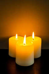 closeup to burning candles in darkness