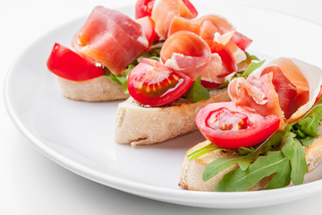 Jamon. Slices of Bread with Spanish Serrano Ham Served as Tapas. Cured ham, spanish appetizer. Prosciutto isolated on white background