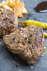 Grilled T-bone steak seasoned with spices and fresh herbs served
