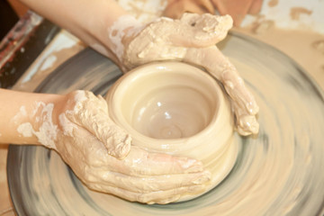Female hands working on pottery wheel