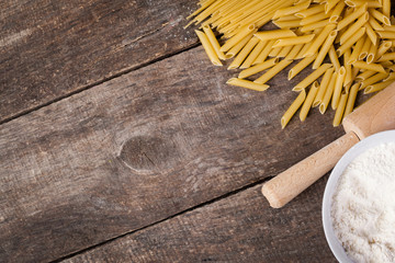 Pasta spaghetti with flour, egg on old wooden background
