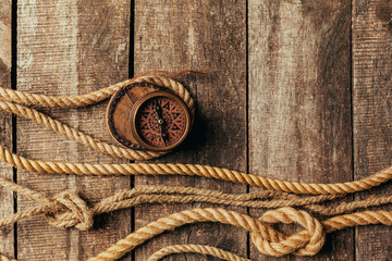 ship ropes and compass on wooden background